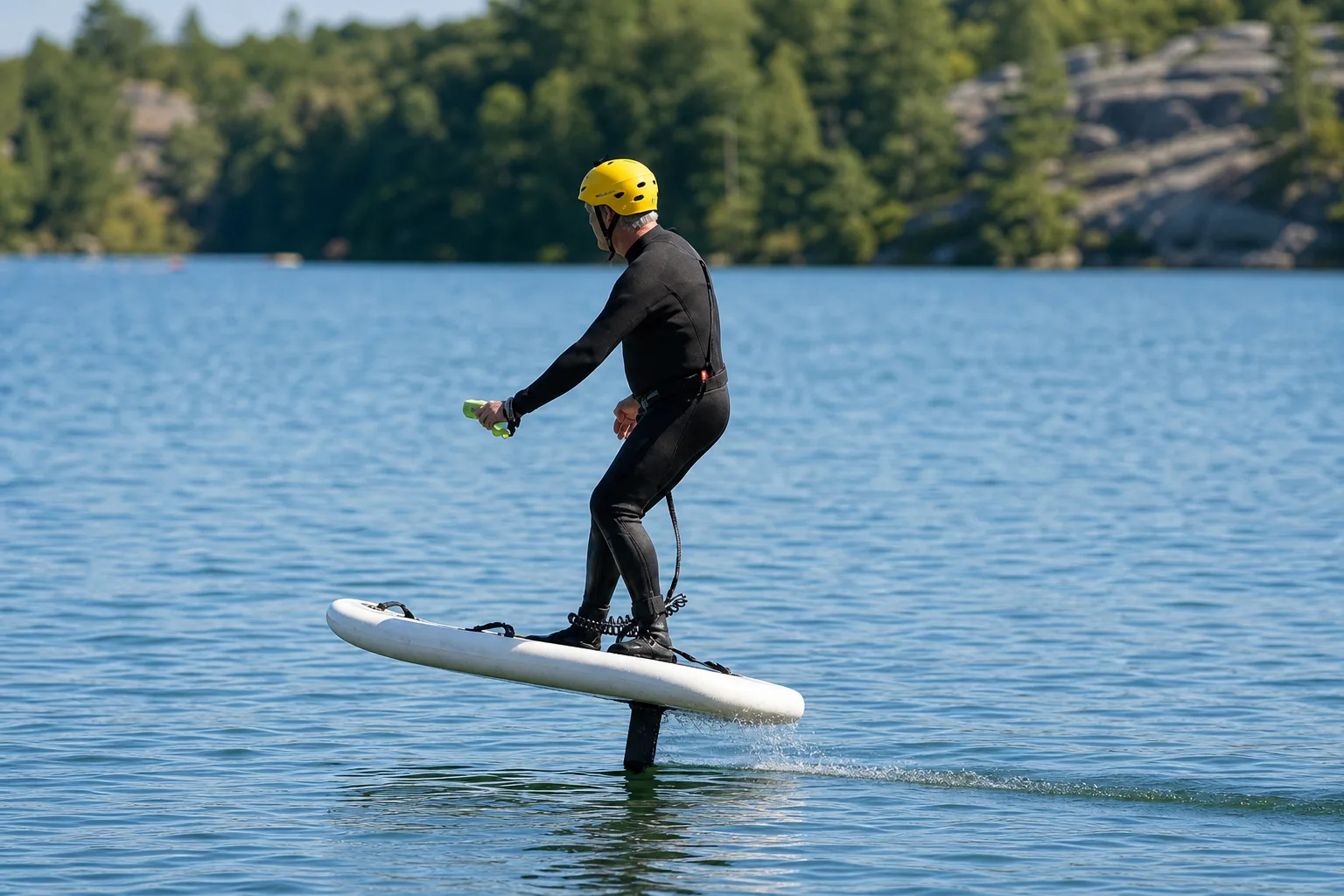 Hydrofoil rider wearing a safety helmet on a cottage-country lake